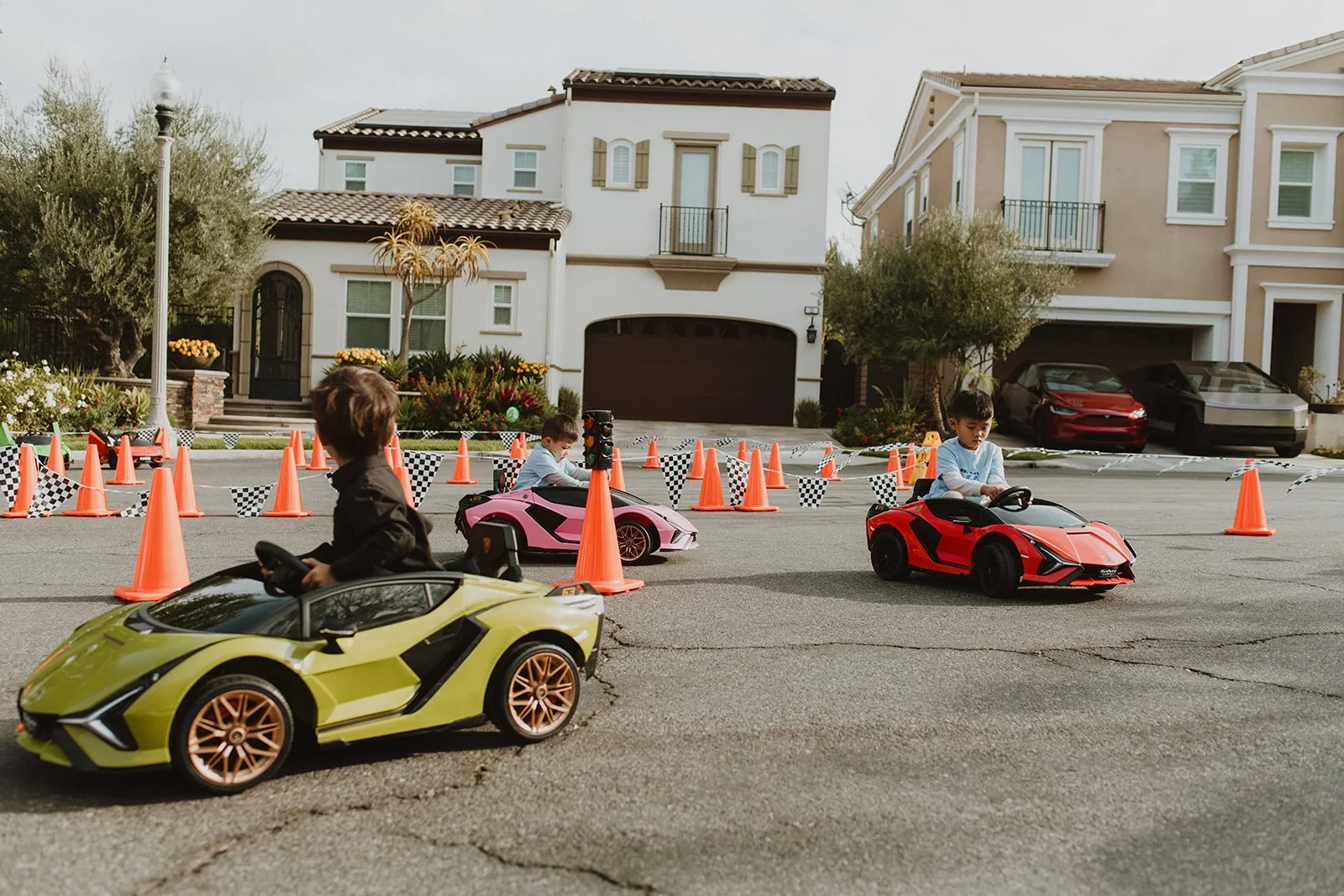 Two branded Little Racers OC ride-on Lamborghinis on a residential race course